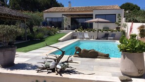 A modern house with a swimming pool, outdoor seating, and a well-maintained garden. - Superb contemporary villa with private pool (Saint-Rémy-de-Provence)
