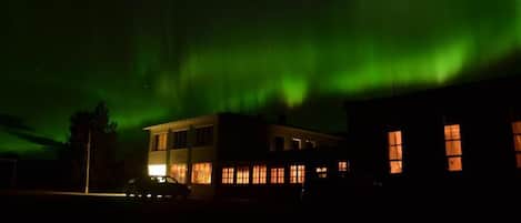Un edificio con varias ventanas e iluminación exterior por la noche.
