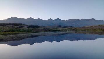 A mountain landscape with a calm lake reflecting the peaks.