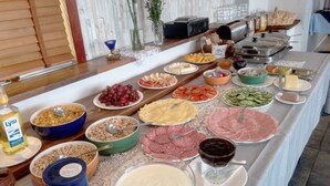 A buffet with various food items including fruits, cheeses, and meats. - Hótel Stadarborg (Fjardabyggd)