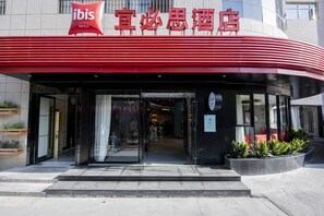 The exterior of ibis hotels with a red awning and glass entrance. - Ibis xi‘an small yanta hotel (Xi'an)