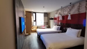 A hotel room with two beds, a TV, a desk with a chair, and a window with curtains. - Ibis Xi'an Jianzhang Road Fengdong New Area Hotel (Xi'an)