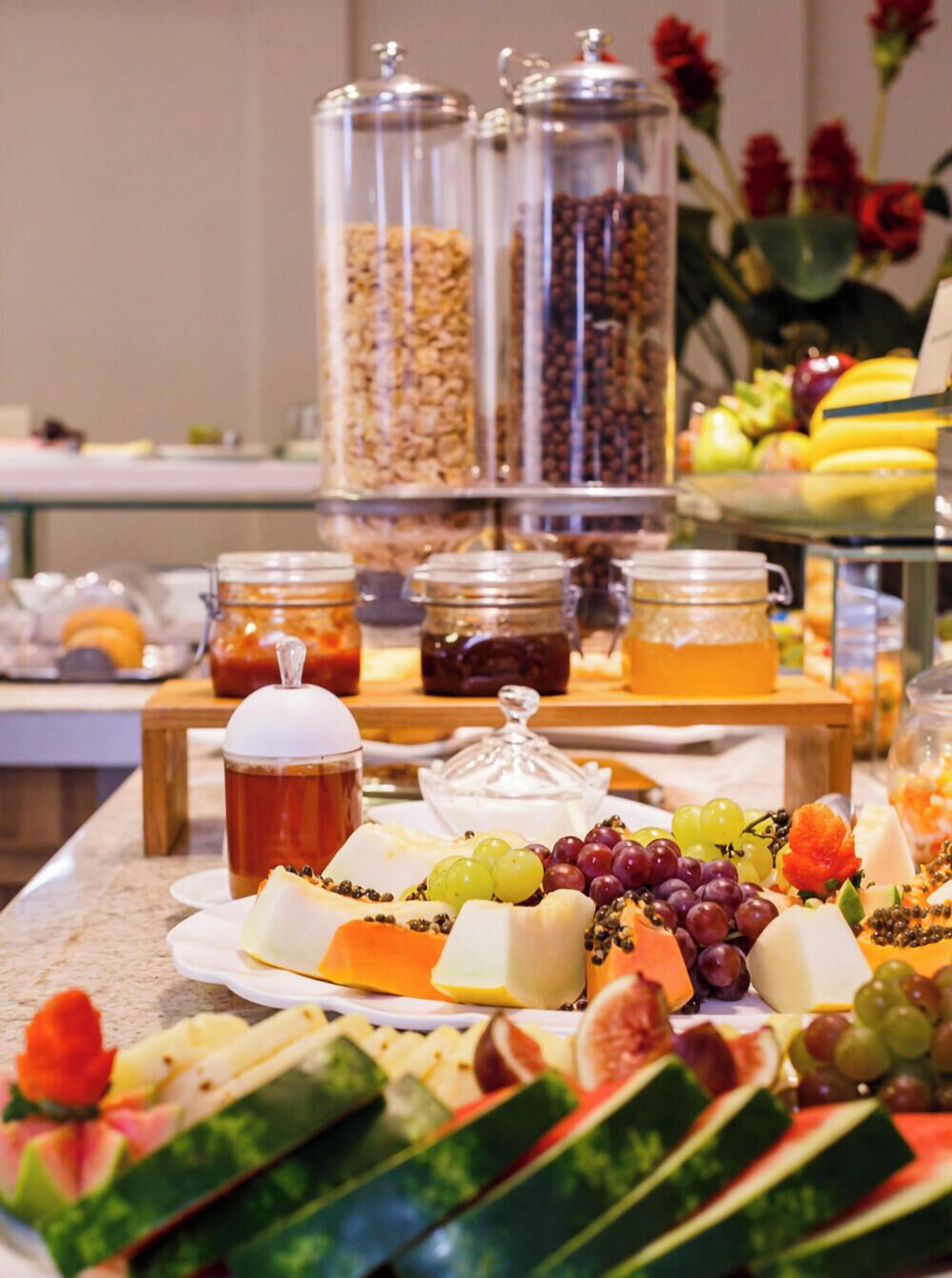 Een buffet met verschillende soorten eten, zoals fruit, kazen en drankjes.