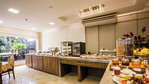 Un espace buffet proposant une variété de plats, un coin café et un réfrigérateur.