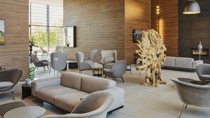 Un interior moderno con un sofá, sillas y una escultura de madera original.