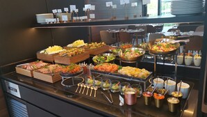 Un buffet proposant une variété de plats et d’ustensiles.