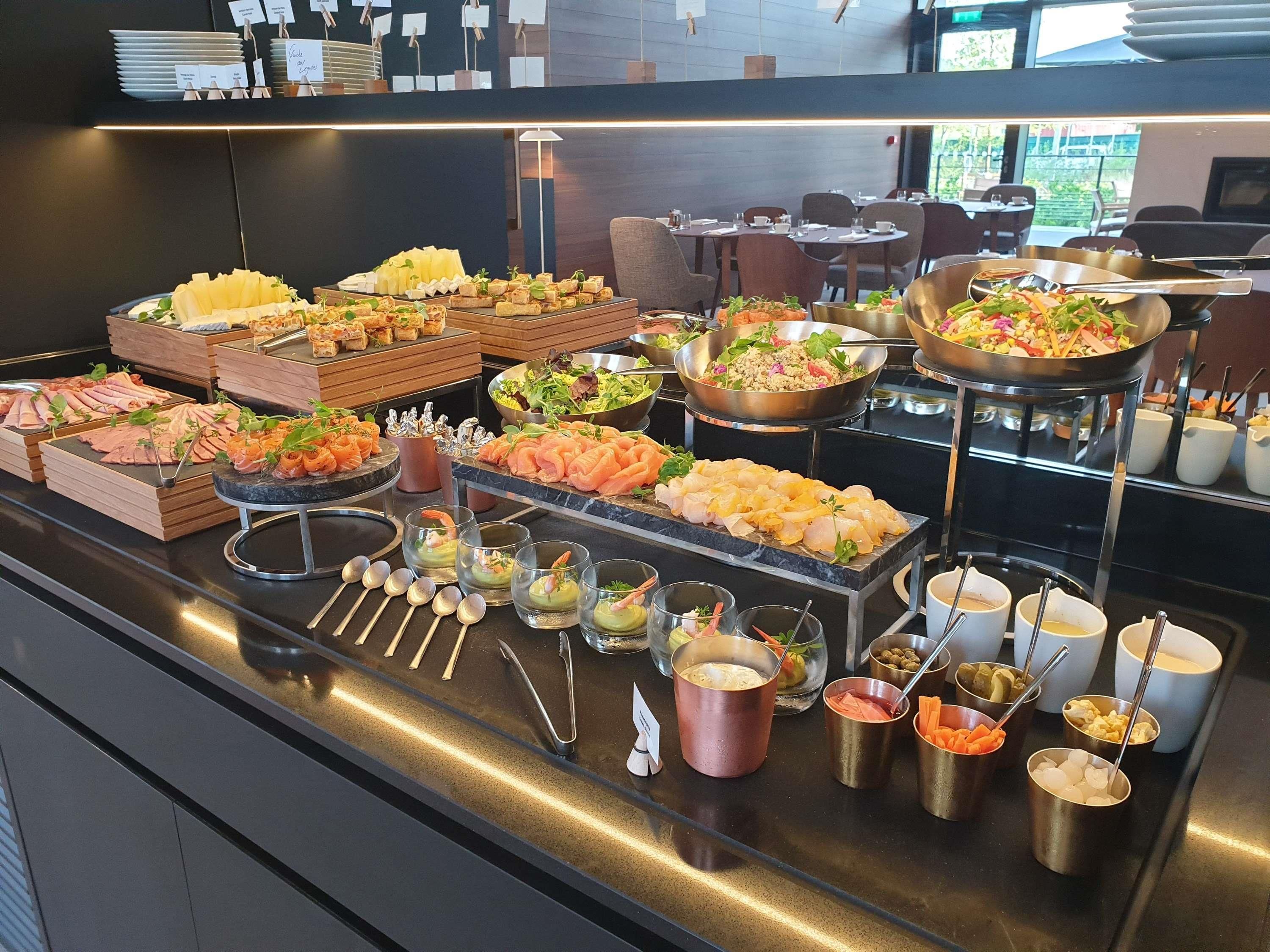 A buffet with various food items and utensils.