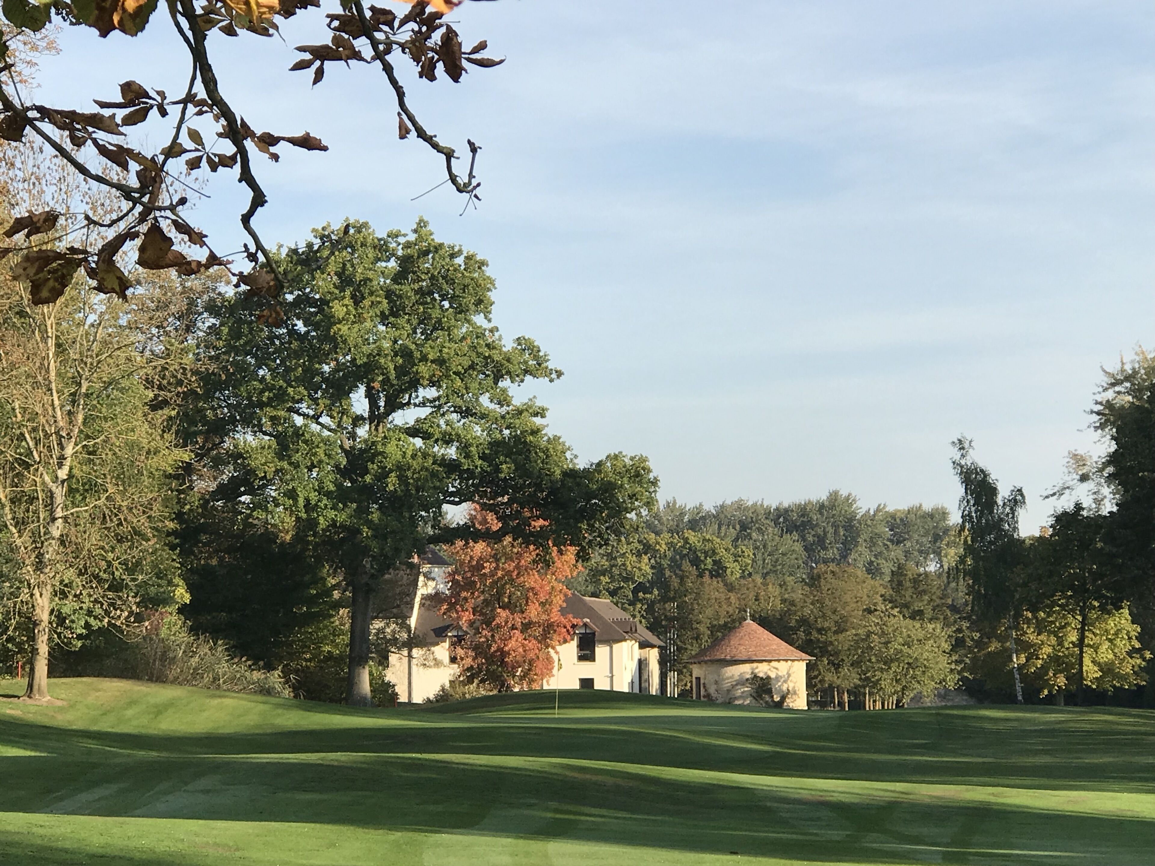 A golf course with a clubhouse and a small pavilion.