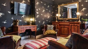 Una habitación con una pared oscura, un espejo grande y un aparador de madera.