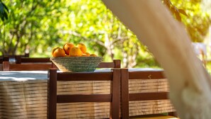 A wooden table with a woven basket containing oranges. - San Simon Hotel (Kemer)