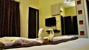 Ein Hotelzimmer mit einem Bett, einem großen Spiegel und einem Fernseher an der Wand.