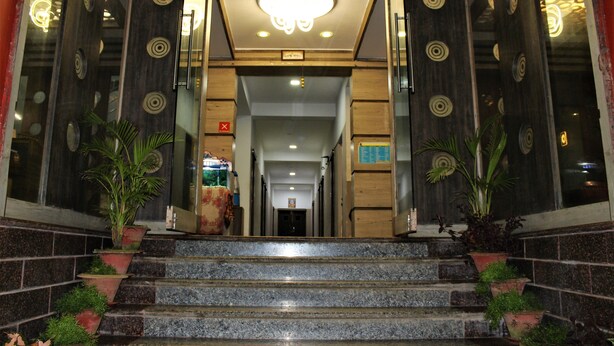 Ein Hotelzugang mit einer imposanten Treppe, Zimmerpflanzen und modernem Design.