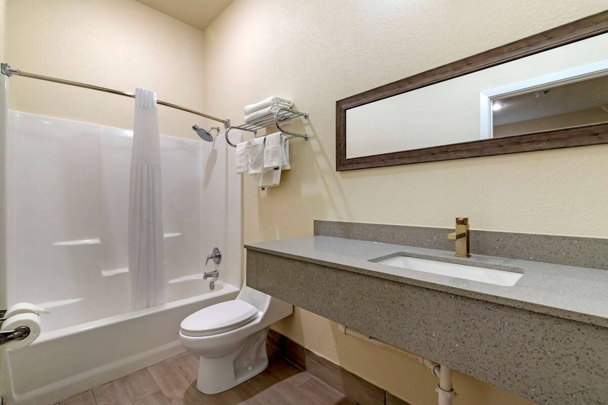 A bathroom with a bathtub, toilet, and sink.
