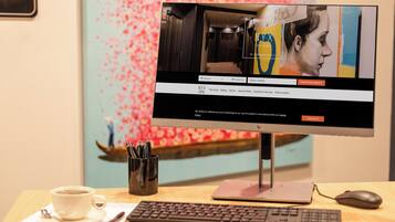 A desktop computer with a monitor displaying a hotel booking website.