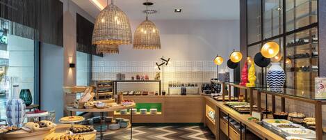Un desayuno buffet moderno con diversos alimentos e iluminación decorativa.