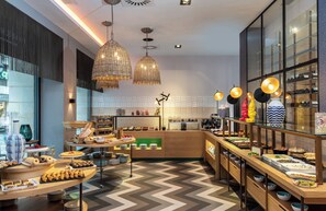 A modern breakfast buffet with various food items and decorative lighting. - NYX Hotel Bilbao by Leonardo Hotels (Bilbao)