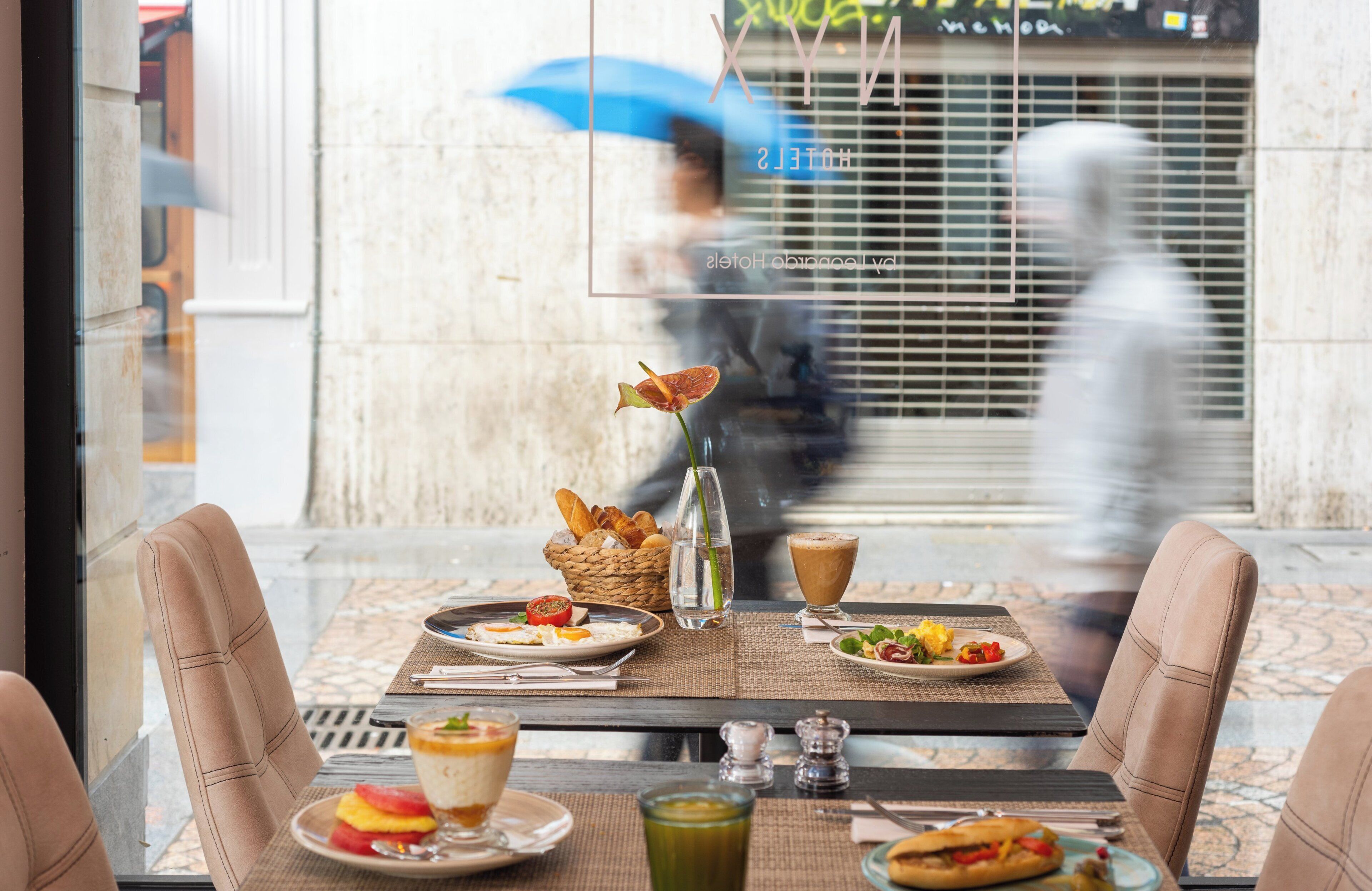 A dining table with plates of food, a vase, and a glass of water.