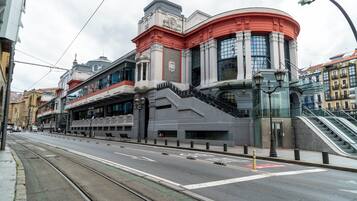A street with a tram line, a building with a curved facade, and an adjacent staircase.