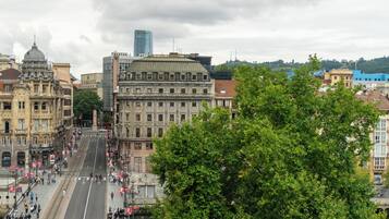 Una calle urbana con edificios históricos, un tranvía y peatones.