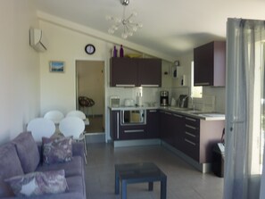 Uma sala de estar moderna com um sofá, uma mesa de centro e uma área de jantar com cadeiras.