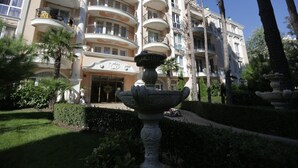 A grand hotel with multiple balconies, a central fountain, and well-maintained gardens. - Luxury Apartment in Anastasia Palace (Sunny Beach)