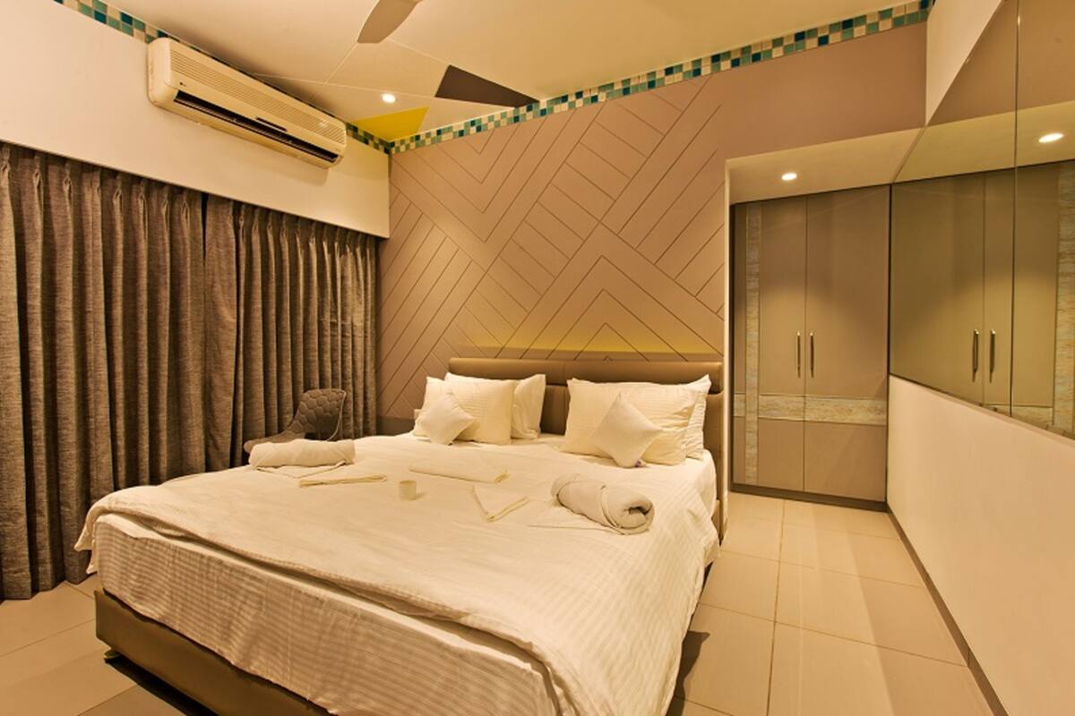Een hotelkamer met een groot bed, een kledingkast en een airconditioning.