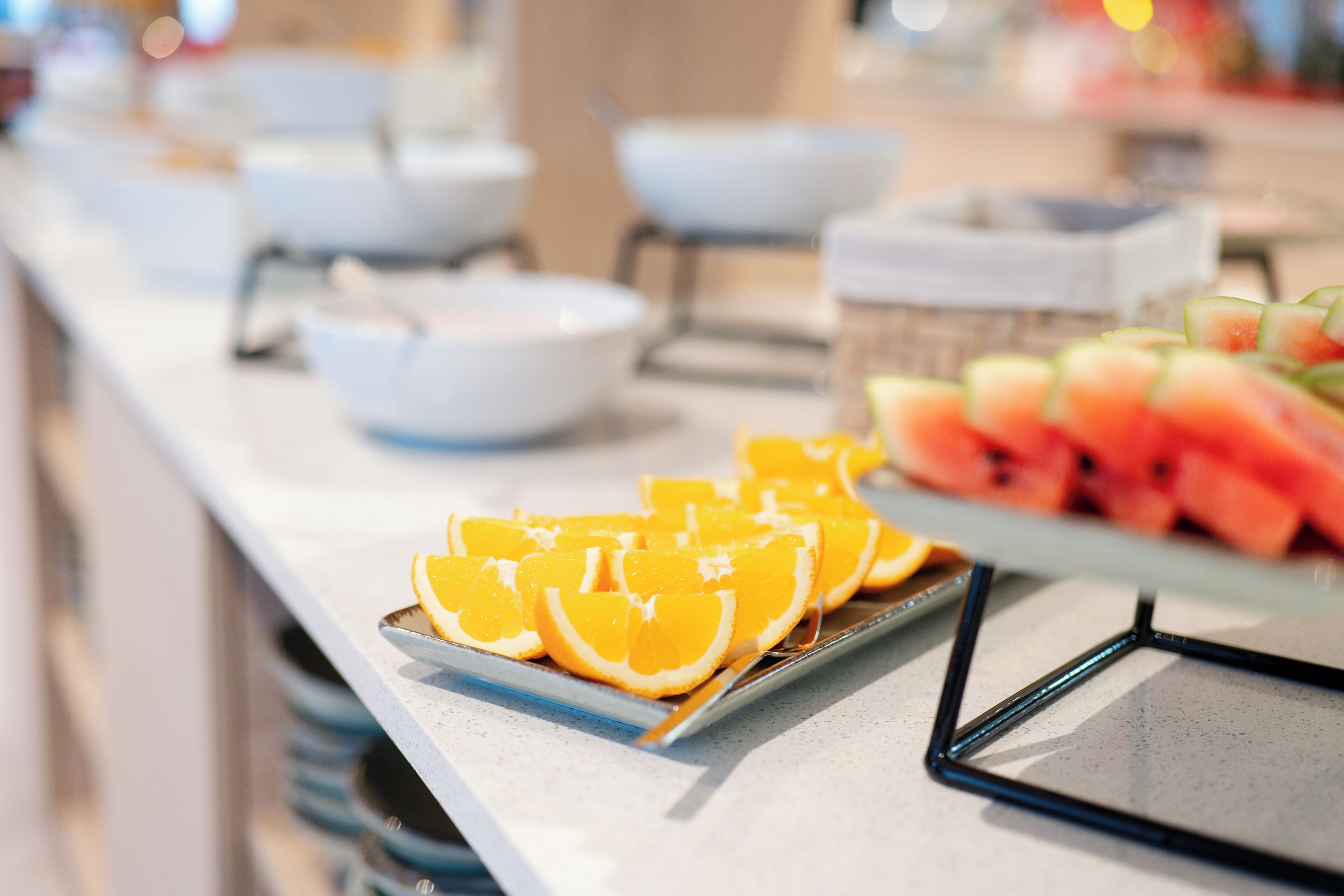 A buffet with various food items including watermelon and orange slices.