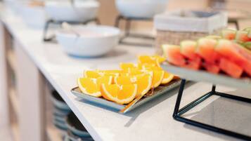 A buffet with various food items including watermelon and orange slices.