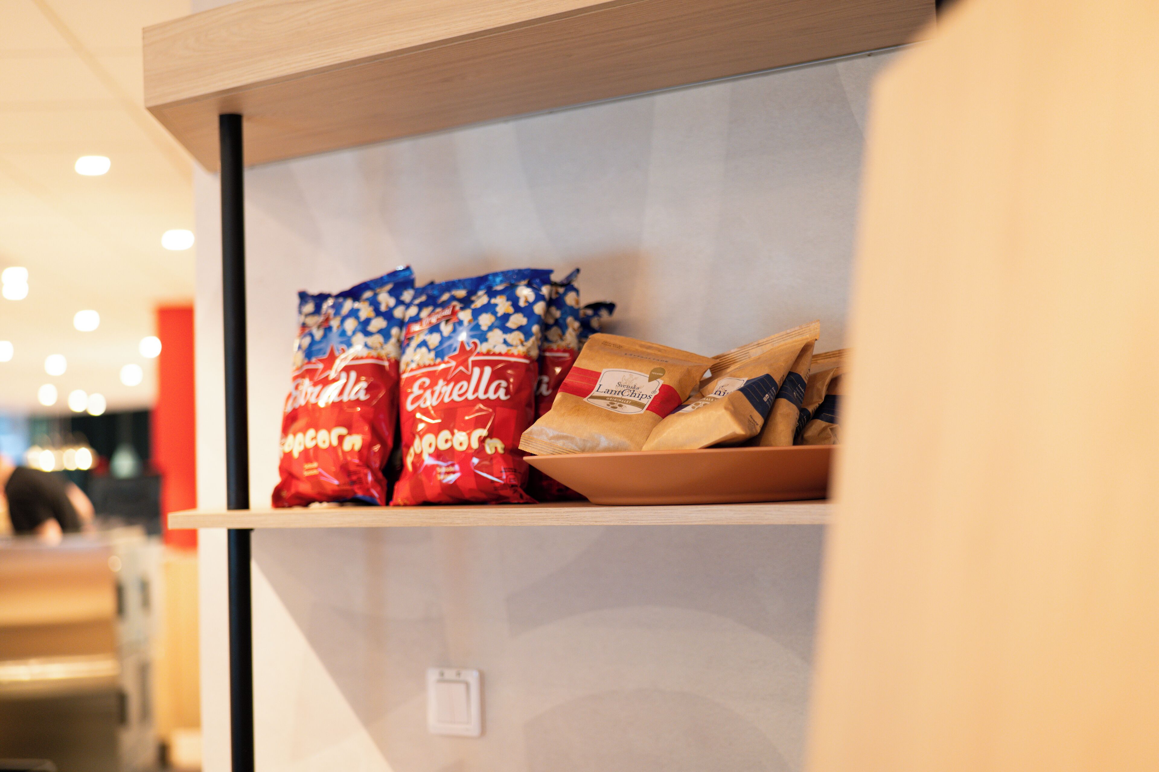 A shelf with popcorn and bread in a store.