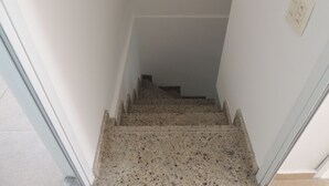 A narrow stairway with a handrail, leading to a landing. - Ótimo Flat 3 Quartos Vista Cristo Redentor (Rio de Janeiro)