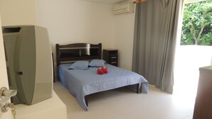 A bedroom with a bed, a television, a dresser, and a window with curtains. - Ótimo Flat 3 Quartos Vista Cristo Redentor (Rio de Janeiro)