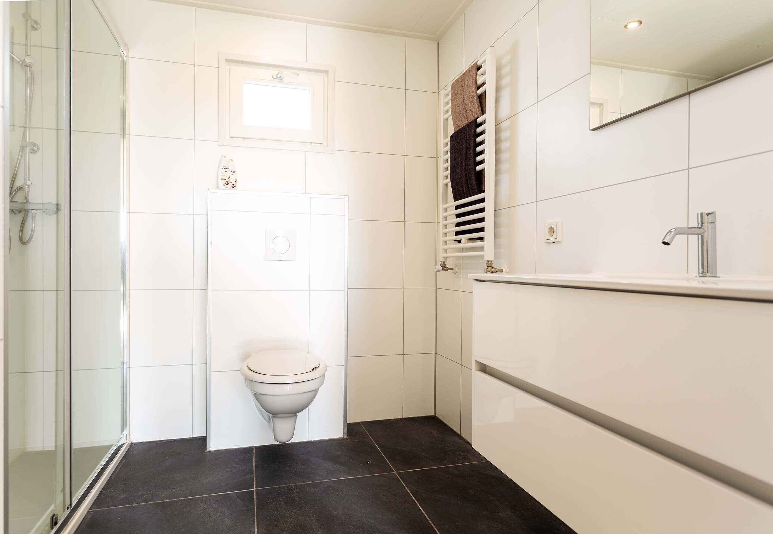 Une salle de bain avec des toilettes, une douche et un lavabo.