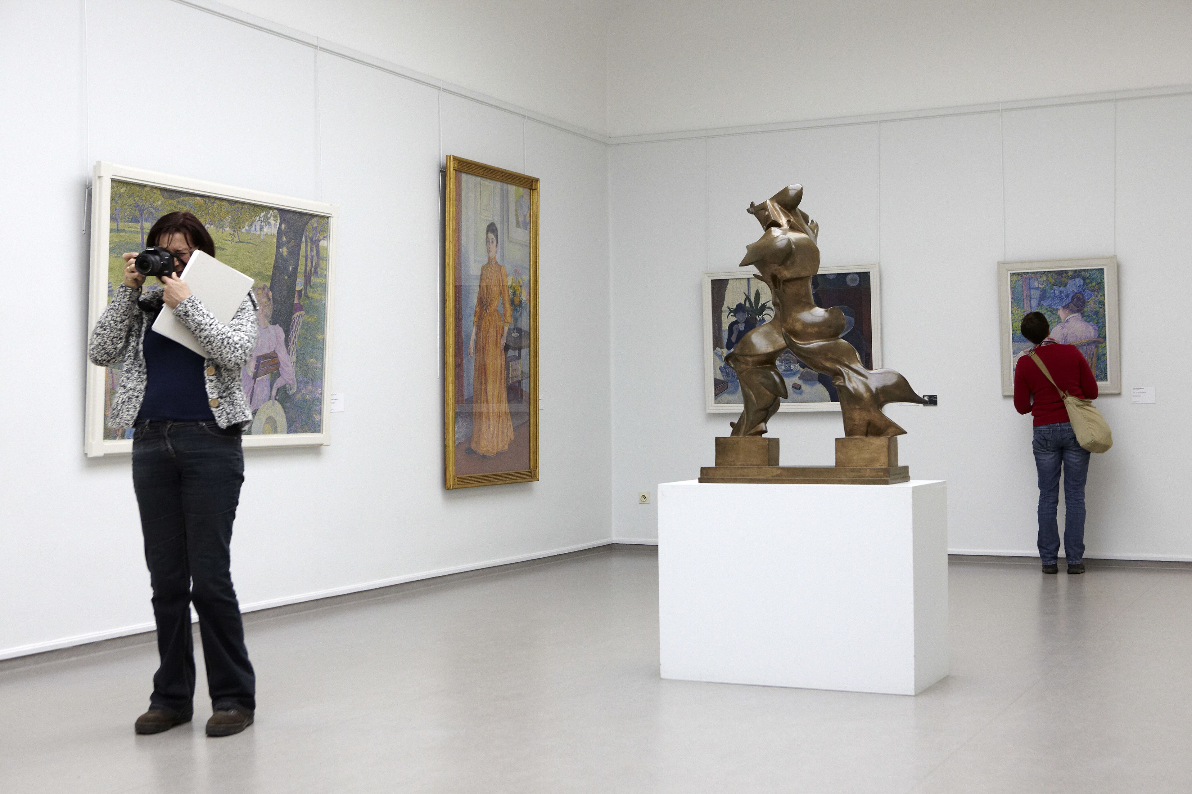 Eine Kunstgalerie mit Gemälden und Skulpturen.