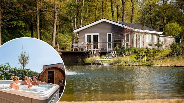 A house with a dock extending into a lake, surrounded by trees.