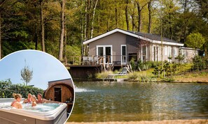 A house with a dock extending into a lake, surrounded by trees. - TopParken Recreatiepark Beekbergen (Beekbergen)