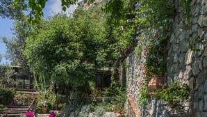 A swimming pool with clear blue water, surrounded by stone walls and lush greenery. - AMORE RENTALS -Villa Era with Swimming Pool, Sea View, Terraces and Parking (Positano)
