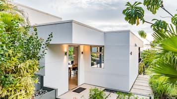 A modern house with a flat roof, large windows, and a well-maintained garden.