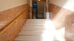 A staircase with a handrail, leading to a landing with a door and a small window. - Apartment Cabo (Split)
