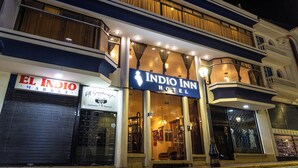 The exterior of the Indigo Inn Hotel with a visible entrance, large windows, and a balcony with curtains. - Hotel Indio Inn (Otavalo)