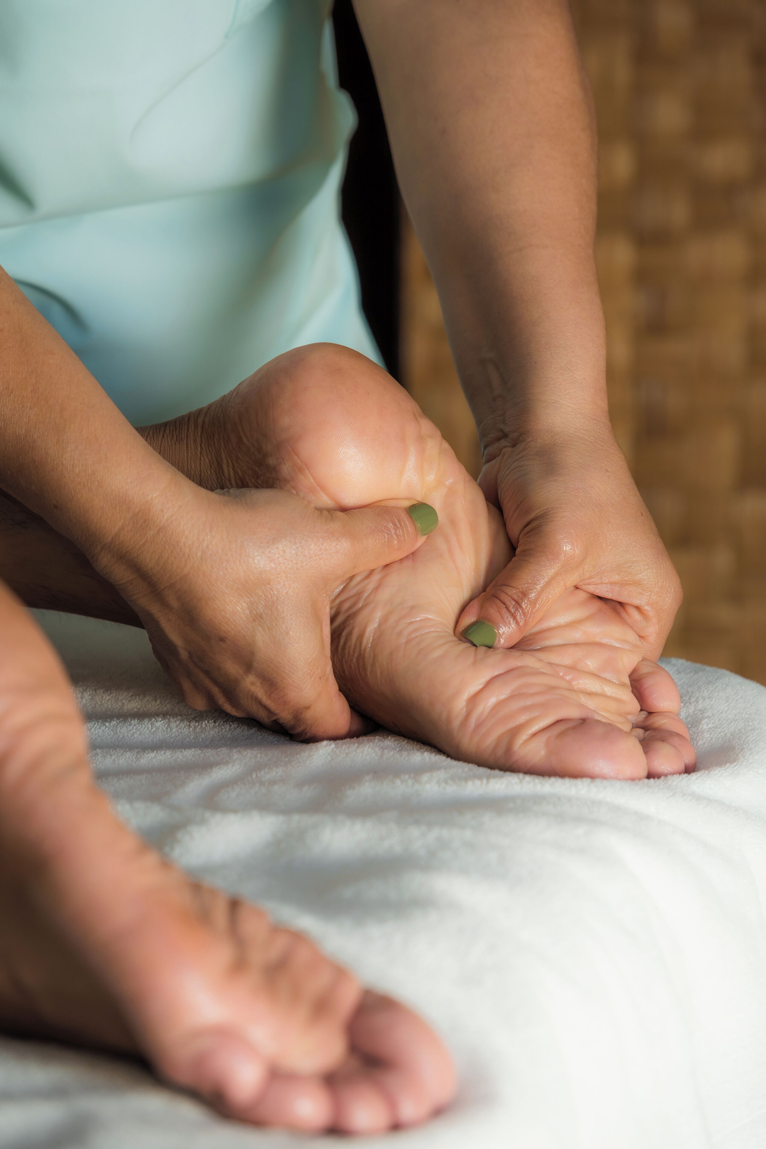 A close-up of hands performing a massage on a foot.