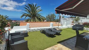 A patio with outdoor furniture, a white fence, and a view of the ocean. - Beautiful bungalow with pool in the area of Los Llanos de Aridane (Los Llanos de Aridane)