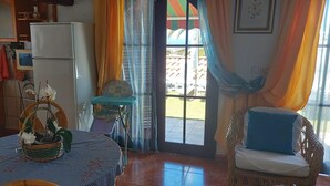 A kitchen with a refrigerator, a dining table with a basket of flowers, and a wicker chair. - Beautiful bungalow with pool in the area of Los Llanos de Aridane (Los Llanos de Aridane)