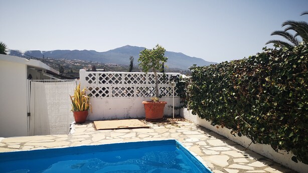 A swimming pool with a view of mountains, surrounded by a white fence and potted plants. - Beautiful bungalow with pool in the area of Los Llanos de Aridane (Los Llanos de Aridane)