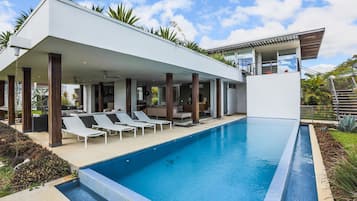 A modern poolside area with lounge chairs and a clear blue pool.