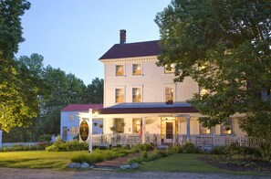 A two-story white building with a red roof, a porch with a white picket fence, and an American flag. - Wakefield Inn & Restaurant (Wakefield)