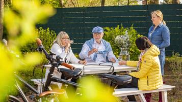 Un grupo de personas sentadas en una mesa al aire libre, con bicicletas al frente.