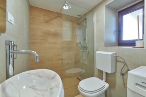 A bathroom with a glass-enclosed shower, a white toilet, and a marble sink. - Holiday home Orihi * 2000 m2 fenced garden, covered terrace, BBQ (Barban)