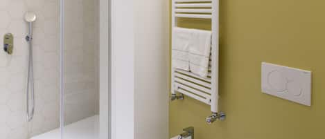 A bathroom with a glass-enclosed shower, a bidet, and a toilet.