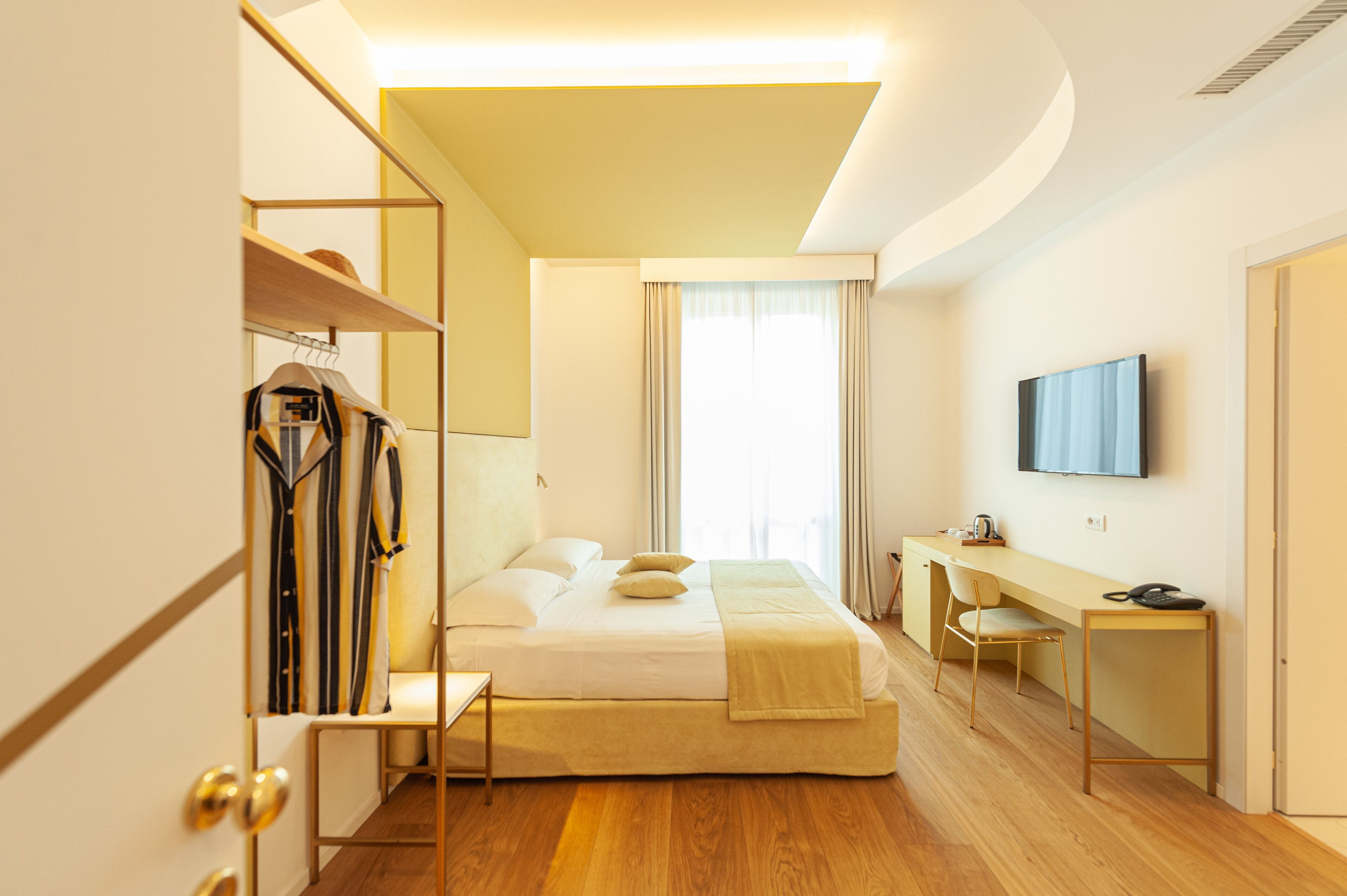 Une chambre d’hôtel moderne équipée d’un lit, d’un bureau, d’une chaise et d’un téléviseur.