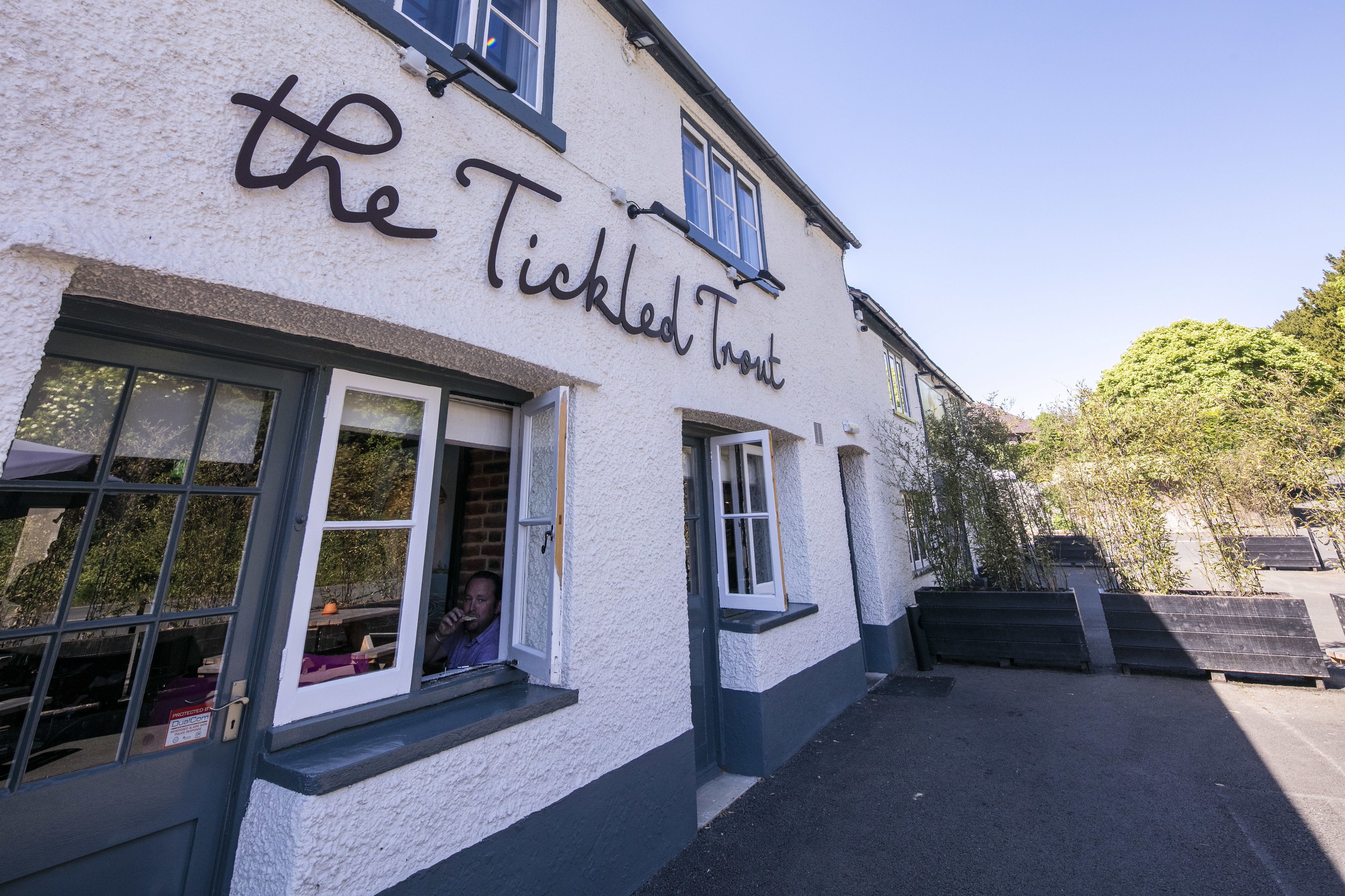 Exterior del pub 'The Tickled Trout', con un letrero claro, ventanas y una entrada visible.